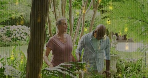 Senior Couple Strolling in Lush Garden Holding Hands
