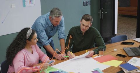 Team Collaborating on Large Diagram During Office Brainstorming and Planning Workshop