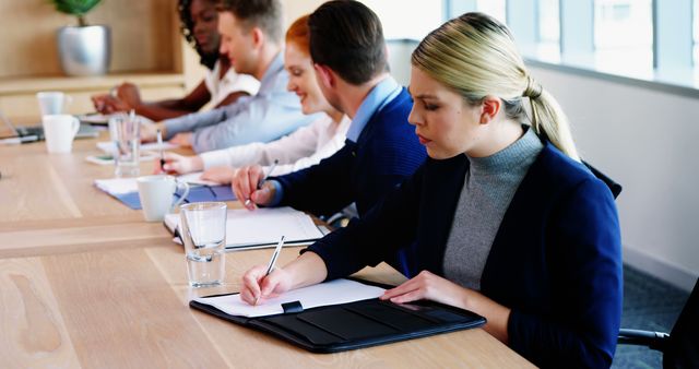 Diverse Group in Meeting Room with Notebooks and Documents - Download Free Stock Images Pikwizard.com