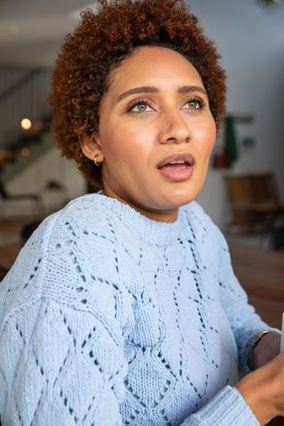 Young Woman Relaxing in Cozy Café with Warm Beverage