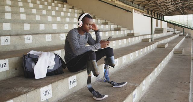 Athletic Man with Prosthetic Legs Sitting in Stadium Stands - Download Free Stock Images Pikwizard.com