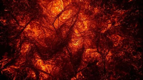 Glowing filaments in fiery furnace interior with molten embers