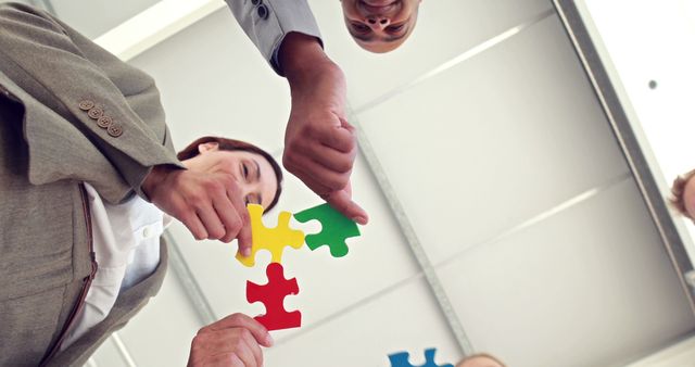 Business colleagues holding pieces of puzzle int the office - Download Free Stock Photos Pikwizard.com