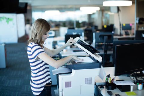 Young professional using copy machine in modern office