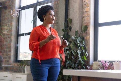 Confident Entrepreneur Presenting Data in Modern Office with Industrial Touch