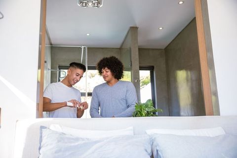 Friends Applying Lotion in Modern Bedroom