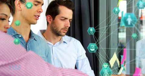 Cross-functional team collaborating on glass wall, placing sticky notes with network overlay