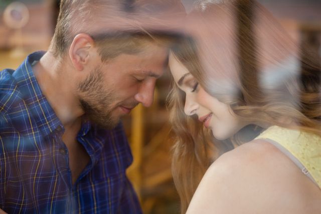 Close up of romantic couple in cafe shop seen through glass window