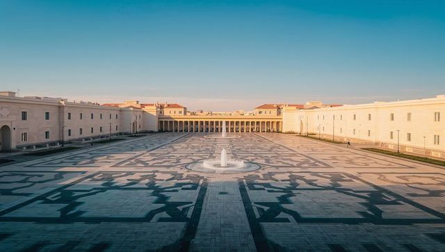 Showcasing neoclassical piazza with symmetrical geometric tile courtyard and fountain