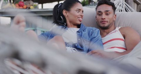 Couple relaxing on hammock by beach