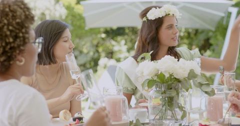 Women Enjoying Wedding Brunch with Flowers and Desserts