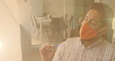 Man Wearing Face Mask Working in Office with Glowing Lights