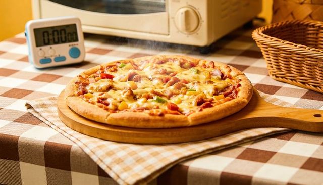 Steaming pepperoni and bell pepper pizza resting on wooden peel with digital kitchen timer