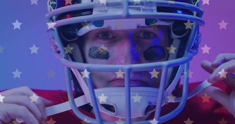 Focused american football player tightening helmet chin strap with star overlay lighting