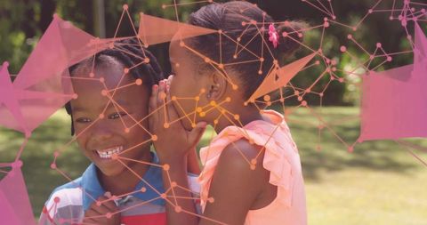 Sister sharing secret with brother in summer lawn overlay