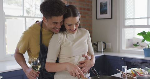 Happy Couple Cooking Together Embracing in Kitchen