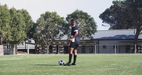 Teen Soccer Player Practicing Dribbling on School Field