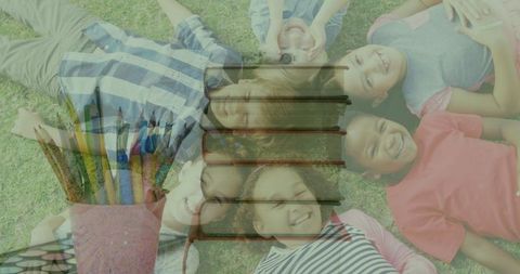 Children Lying on Grass with Symbols of Education and Reading