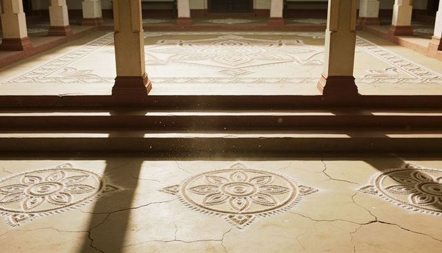 Sunlight highlighting cloister rosettes and column shadows on weathered cracked floor