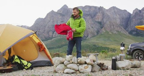 Camper Preparing Gear at Mountain Camp