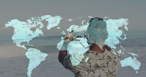 Man Photographing Ocean with World Map Overlay Illustrating Global Exploration