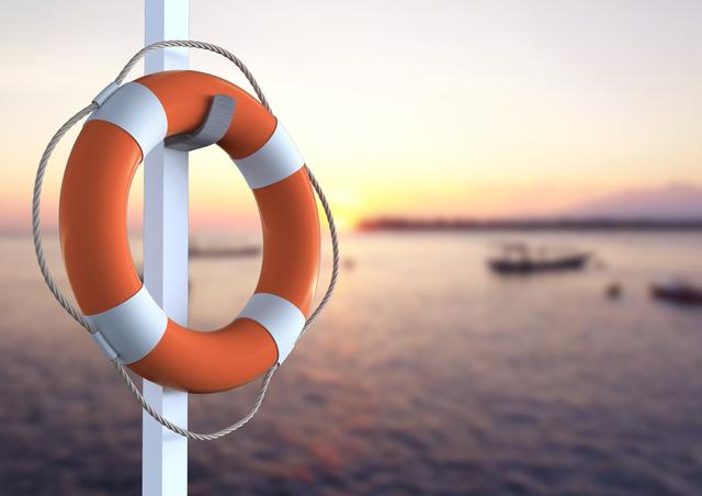 Lifebuoy hanging on a pole with a serene waterfront in the background during sunset. Ideal for themes related to safety, maritime activities, rescue operations, and tranquil evening scenes by the water. Suitable for use in articles, blogs, and promotional materials about water safety, boating, and coastal life.