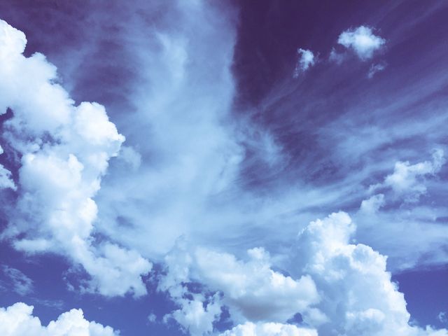 Dynamic cloud formations floating in a vibrant blue sky. Could be used for weather-related content, nature wallpapers, or relaxation themes. Ideal for illustrating peaceful, atmospheric scenes or promoting aviation and travel content.