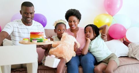 Happy Family Celebrating Birthday with Cake and Balloons at Home