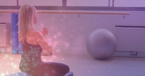Caucasian Woman Practicing Yoga and Meditation with Sparkling Light Effects