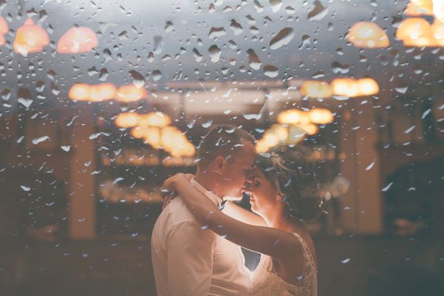 Newlyweds Embracing Behind Rain-Soaked Glass With Warm Background Lighting - Download Free Stock Photos Pikwizard.com