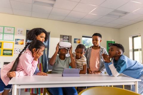 Multiracial students exploring virtual reality with tablet in classroom collaboration