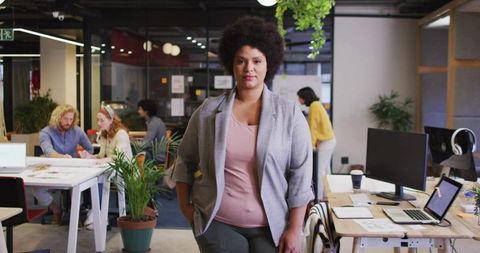 Black woman leading diverse team in modern open-plan office promoting collaboration