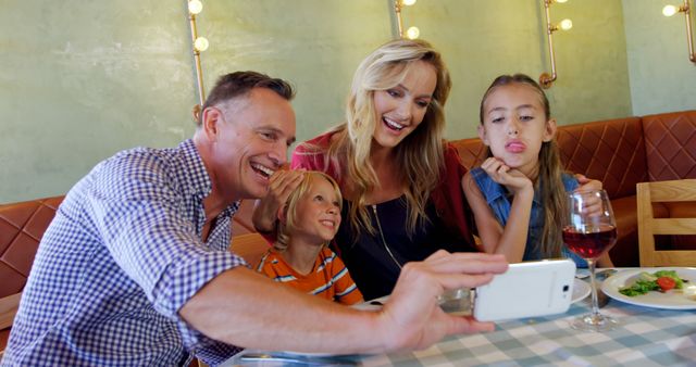 Happy Family Taking Restaurant Selfie While Daughter Makes Funny Face - Download Free Stock Images Pikwizard.com