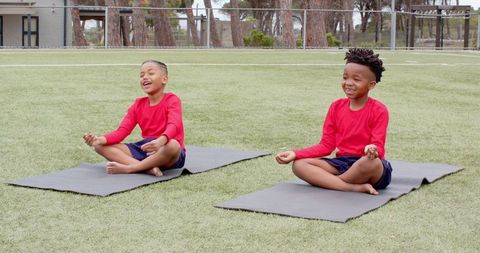 Diverse Child Friends Meditating Together Outdoors on Turf