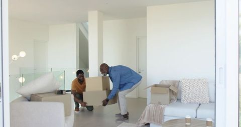 Father and Son Moving Boxes in Modern Living Space