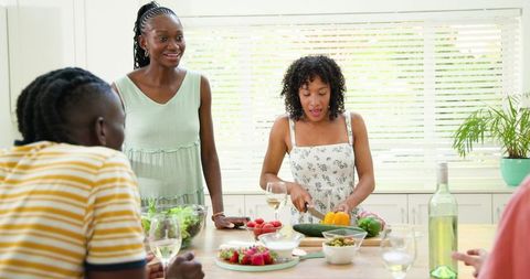 Friends Gathering and Cooking Together in Bright Kitchen