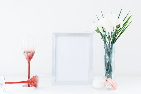 Elegant table setup with picture frame, wine glasses, and white flowers