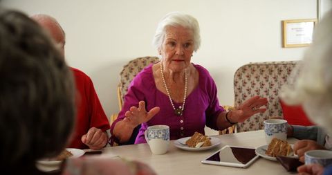Senior Woman Engaging in Conversation at Social Gathering