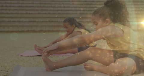 Schoolgirls Enjoying Outdoor Yoga Session with Bokeh Lights