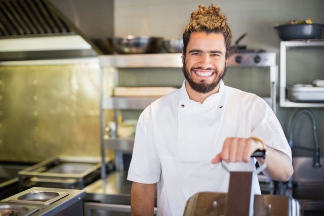 Portrait of smiling male chef standing in commercial kitchen