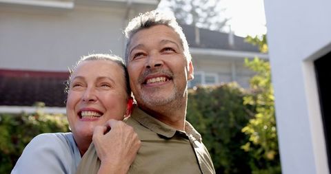 Happy Couple Embracing Outdoors in Sunlit Backyard