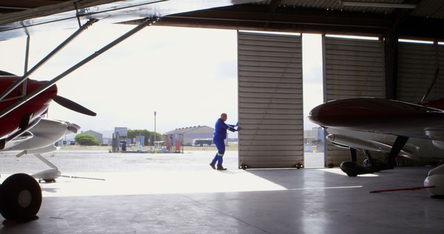Mechanic Opening Hangar Doors at Aircraft Maintenance Facility - Download Free Stock Images Pikwizard.com