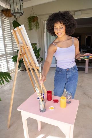 African American Woman Enjoying Outdoor Painting in Rustic Setting