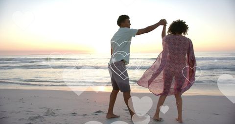 Romantic Couple Dancing on Sunset Beach with Hearts