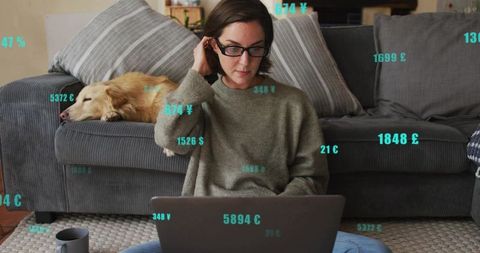 Woman working on laptop in cozy living room