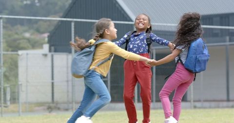 Joyful Group of Diverse Schoolgirls Dancing Outside School