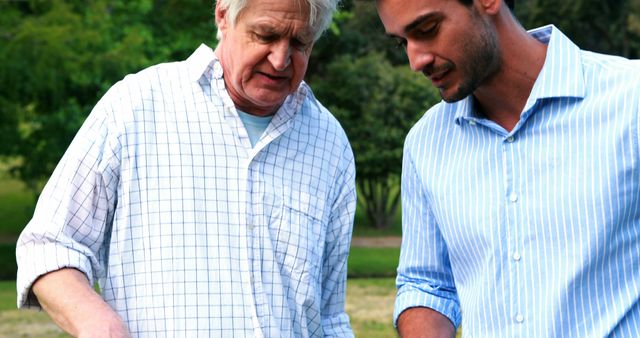 Senior Man and Young Man Having Outdoor Discussion in Park - Download Free Stock Images Pikwizard.com