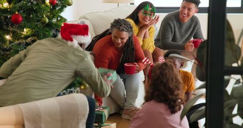 Diverse Family Celebrating Holiday Together Cheerfully by Christmas Tree