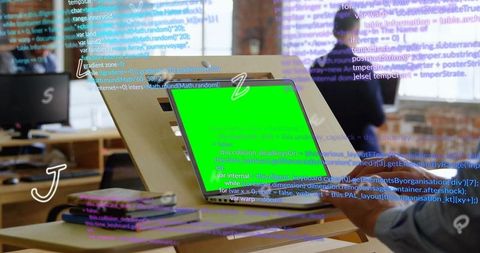 Developer typing on laptop with green screen and floating code overlay in coworking loft