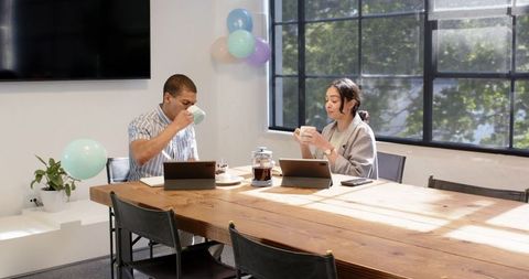 Colleagues celebrating office birthday with coffee and decorations